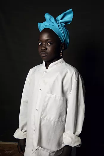 Portretfoto van een kind met een witte blouse en een blauw hoofdband