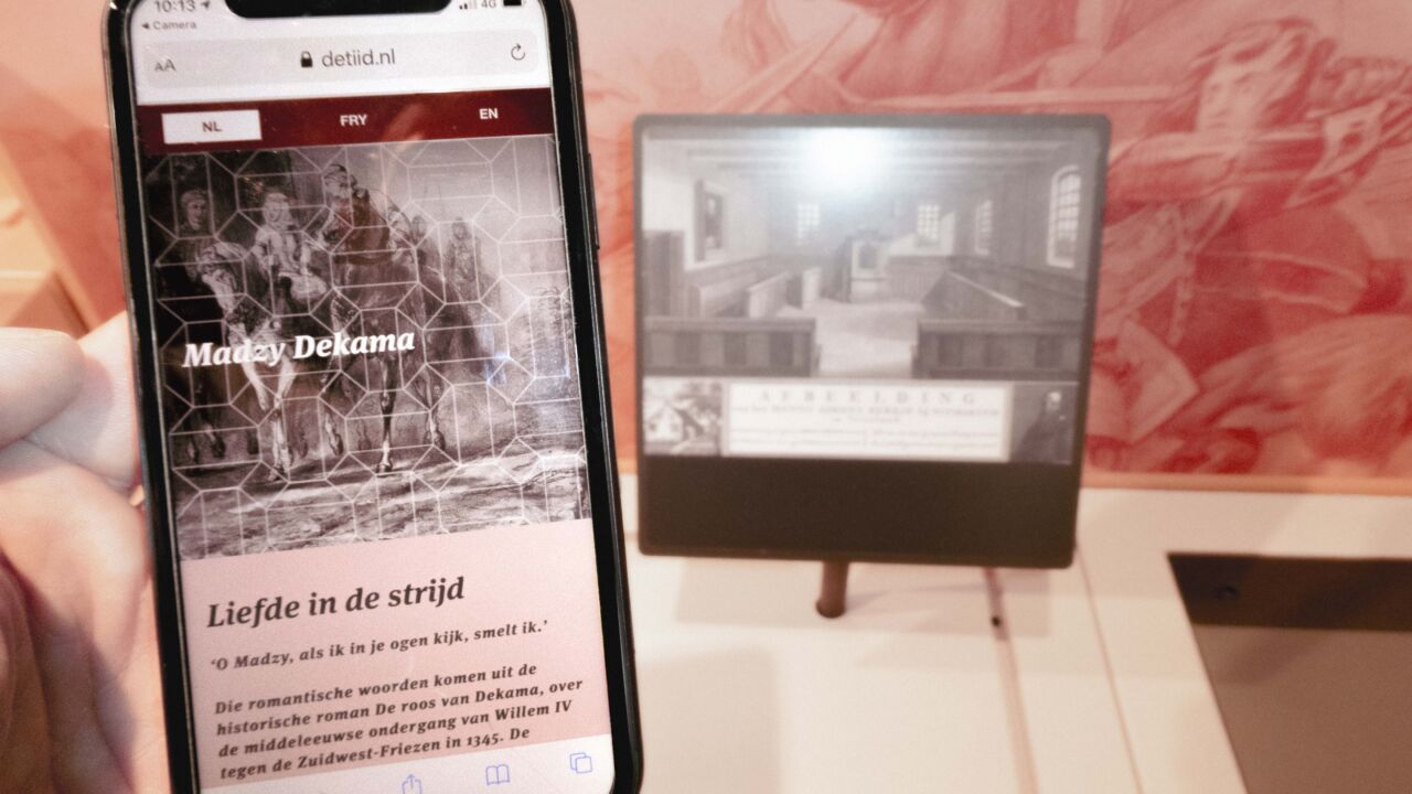 Telefoon wordt voor een bord van het museum gehouden.