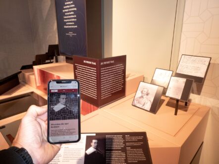 Een hand houdt een telefoon op met daarop informatie verkregen via de QR-code op het eiland.