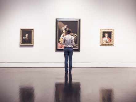 Vrouw kijkt naar schilderij in gallerij